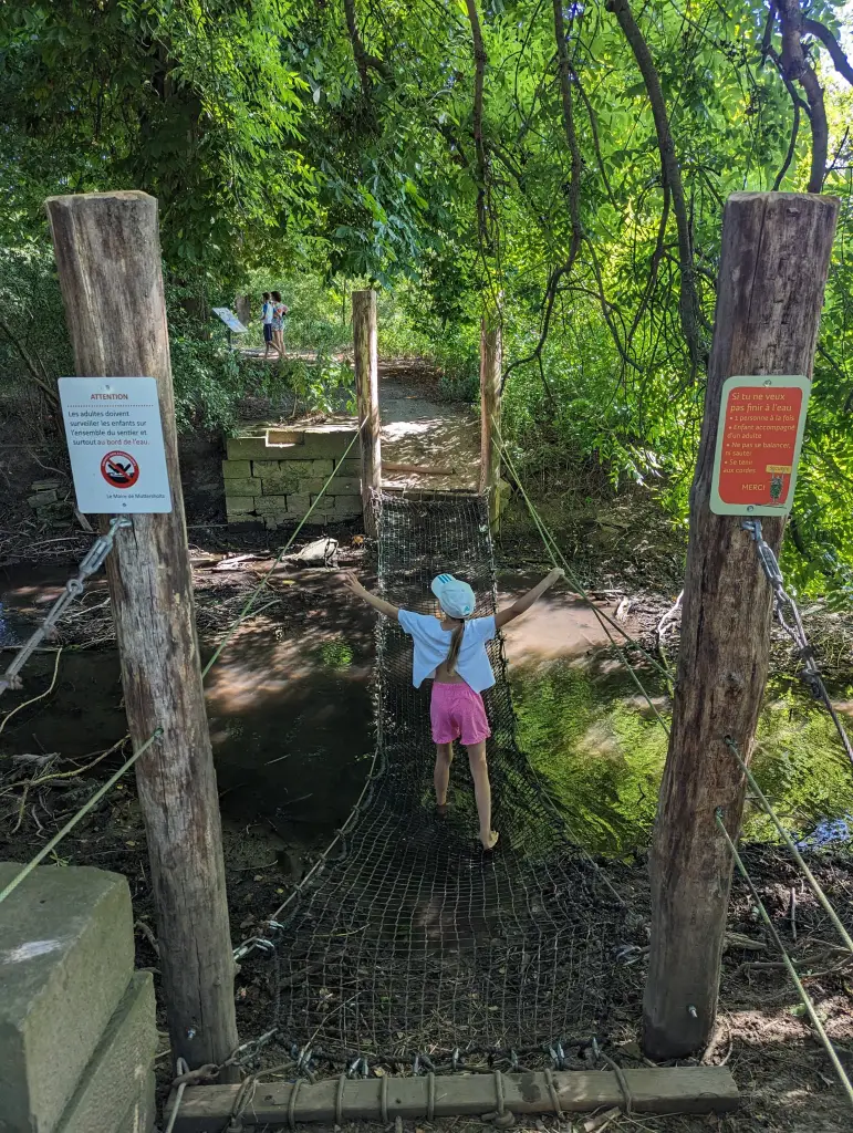 On the trail: Erika walking over the stream by net bridge