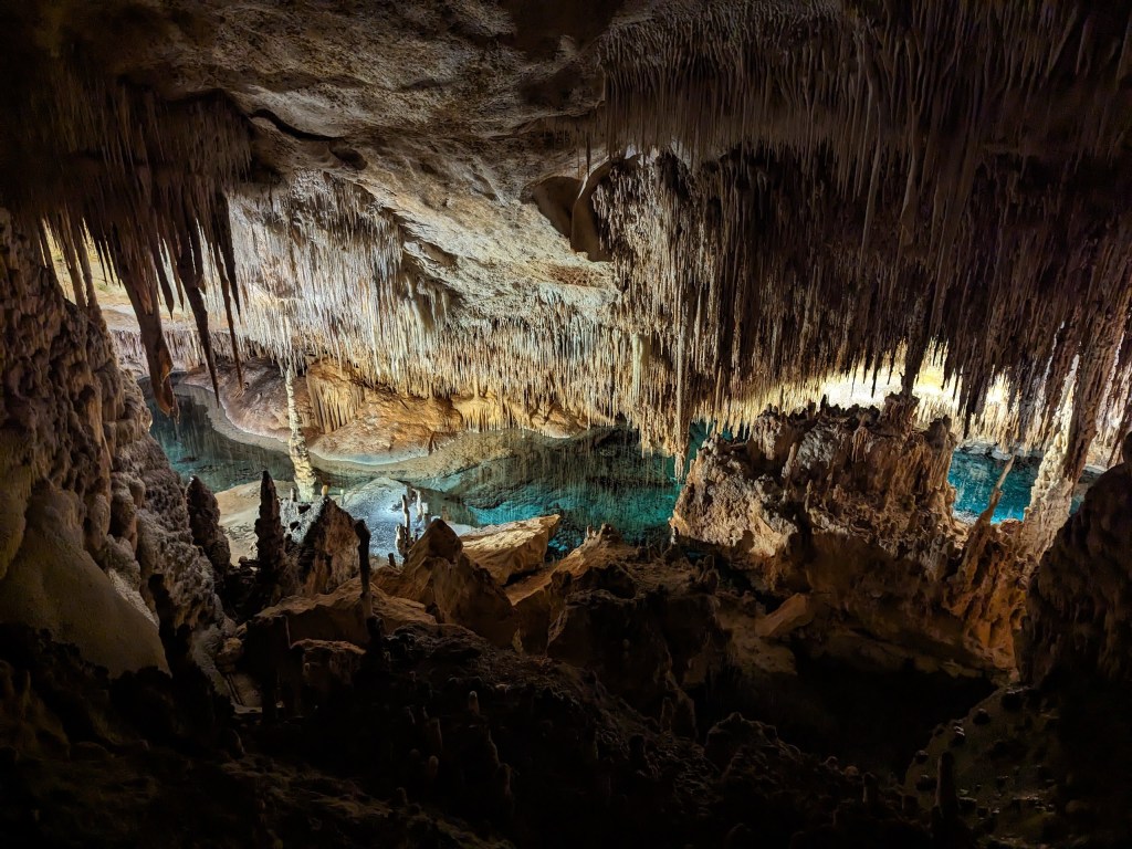 The water in the lake is crystal clear and framed by stalactites and stalagmites