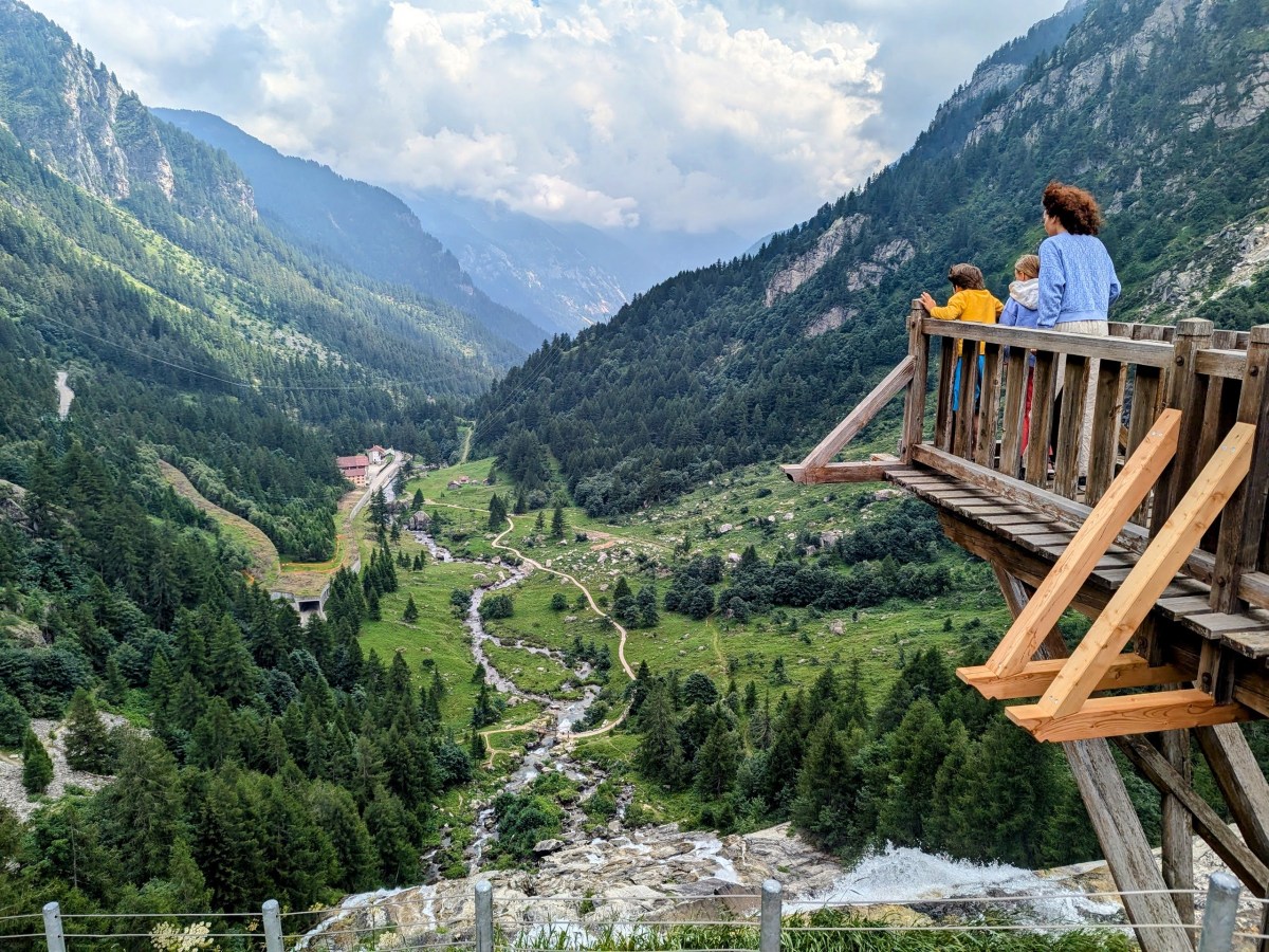 a group of people on a wooden deck overlooking a valley